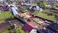 Village with wooden house under construction. Clip. Top view of process of construction of wooden house on background of