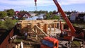 Village with wooden house under construction. Clip. Top view of process of construction of wooden house on background of