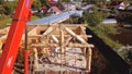 Village with wooden house under construction. Clip. Top view of process of construction of wooden house on background of