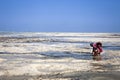 A villager farming seaweed during low tide in Zanzibar.