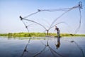 Villagers are casting fish. Fisherman Fishing Nets. Throwing fishing net during morning on a wooden boat, Thailand