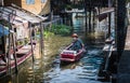 Villagers row a boat in a canal to enter the Hua Takhe Market Community House, Thailand.