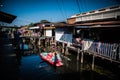 Villagers row a boat in a canal to enter the Hua Takhe Market Community House, Thailand.