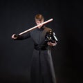 A villain with a red lightsaber, a young man in a long robe does fighting poses, Royalty Free Stock Photo