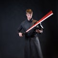 A villain with a red lightsaber, a young man in a long robe does fighting poses, Royalty Free Stock Photo