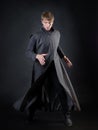 A villain with a red lightsaber, a young man in a long robe does fighting poses,