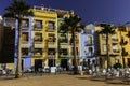 Villajoyosa, Spain - July 3, 2018: Cafe, colorful houses and palms on the street in Villajoyosa on a sunny day