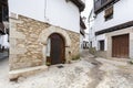 An old traditional house with stone archway at the front door and granite stone facade with some small potted plants outside in Royalty Free Stock Photo