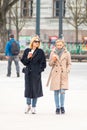 Beautiful couple of blond hair girls without mask walking and drinking coffee in the city