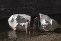 Vilnius Old Town. Girls take pictures of a giant mirror head in the river Royalty Free Stock Photo