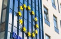 EU sign of 12 golden stars in the shape of a circle on the facade of a glass building