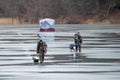 Fishermen leaving after fishing on a frozen lake in winter