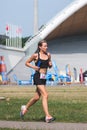 Beautiful blond girl in sport clothes running in the park