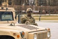 United States Marine Corps soldier with covered face and sunglasses, shotgun and armored vehicle humvee