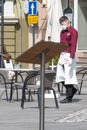 Waiter with a mask at an outdoor open air bar, cafÃÂ© or restaurant