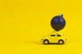 Vilnius, Lithuania - November 15, 2019: Yellow retro toy model car with small navy Christmas tree decoration bauble on