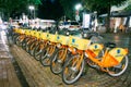 Vilnius Lithuania. Row Of Bicycles Aviva For Rent At Lit Bike Parking On Wet Cobblestone Of Pilies Street Royalty Free Stock Photo