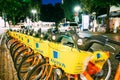 Vilnius Lithuania. Row Of Bicycles Aviva For Rent At Lit Bike Parking On Wet Pilies Street, Night Royalty Free Stock Photo