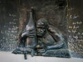 Bronze bas-relief of a drunkard with a big bottle of wine and a cat in Uzupis, Vilnius, Lithuania. . Royalty Free Stock Photo