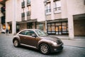 Side View Of Brown Volkswagen New Beetle Hatchback Coupe Car In Motion On Street.