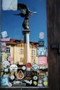 Statue of an angel blowing a trumpet, reflected in the glass door, Uzupio district, Vilnius, Lithuantown. Royalty Free Stock Photo