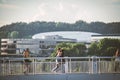 Vilnius, Lithuania 03 06 2022: Young people and men walking on a white bridge over river with green trees and office building on