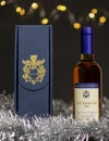Vin Santo bottle out of the cardboard box with the producer`s coat of arms and a typical Christmas gift composition