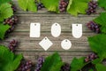 Vine with pink grapes and leaves around on vintage rustic wooden table. Set of differents paper tags template in center. Royalty Free Stock Photo