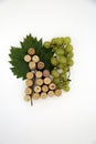 White grapes and grape figure from the wine corks and vine on white background. Copy space. Royalty Free Stock Photo