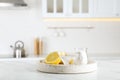 Vinegar, baking soda and lemon on white marble table in kitchen. Eco friendly natural detergents