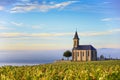 Vineyards and church in Beaujolais with a large blue sky at sunrise Royalty Free Stock Photo