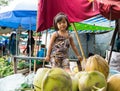 Vinh Long, Vietnam - Nov 30, 2014: Unidentified child plays alone among a lot of fruits at Vinh Long market, Mekong delta. Almost