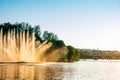 Vinnitsa, Ukraine. Color fountain on the lake in summer sunny day. Dancing fountain on green park background. Fountains show