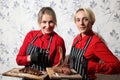Girls waitresses with steaks. Medium-roasted steak cut into pieces on a wooden board with sauce and seasonings. Beef steak on wood