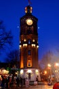 Unidentified people celebrate New Year Eve near old fire tower with clock at night, Vinnytsia, Ukraine