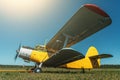 Vintage aircraft on green grass and blue sky background in sunlight. Old retro airplane Royalty Free Stock Photo