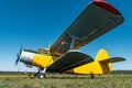 Vintage aircraft on green grass and blue sky background in sunlight. Old retro airplane Royalty Free Stock Photo