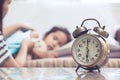 Vintage alarm clock on background of mother taking care child Royalty Free Stock Photo