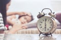 Vintage alarm clock on background of mother taking care child Royalty Free Stock Photo