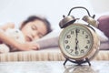 Vintage alarm clock on cute asian child girl sleeping in the bed Royalty Free Stock Photo