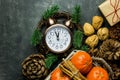 Vintage alarm clock set to five minuted to midnight. New Year`s eve countdown. Pince cones walnuts tangerines cinnamon sticks gift Royalty Free Stock Photo