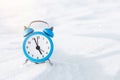 Vintage alarm clock on the snow. The concept of Christmas and New Year. Magic composition.