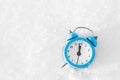 Vintage alarm clock on the snow at sunset. The concept of Christmas and New Year. Royalty Free Stock Photo