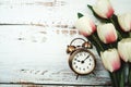 Vintage Alarm Clock And Tulip Bouquet with space copy on wooden background Royalty Free Stock Photo