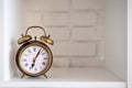 Vintage alarm clock on a white shelf