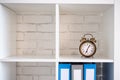 Vintage alarm clock on a white shelf