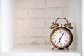 Vintage alarm clock on a white shelf