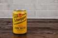 A vintage aluminium can of Schweppes beer against the brick wall