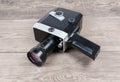 Vintage amateur mechanical movie camera on an old wooden surface