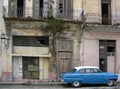 Vintage American blue car, parked outside a derelict bulling in Havana, Cuba